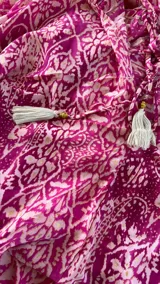 Vestido largo magenta con estampado caleidoscópico, cuello halter y falda en capas.