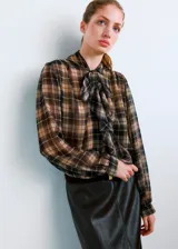 Blusa de manga larga con estampado de cuadros en tonos marrones y grises, cuello clásico y cierre frontal con botones ocultos.