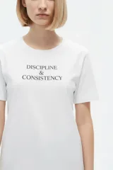 Remera negra de algodón con cuello redondo, manga corta y estampa frontal con texto en blanco.