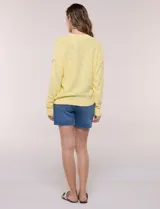 Cardigan blanco de punto liviano y texturado, de corte holgado y diseño casual. Cuenta con escote en V pronunciado, abotonadura frontal, mangas largas con hombros caídos y bolsillos delanteros tipo parche.