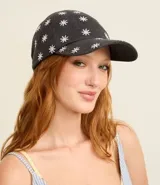 Gorra de sarga de algodón con visera curva y ajuste trasero. Presenta un estampado integral de margaritas blancas sobre fondo gris oscuro.