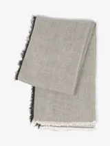 Bufanda de tejido suave y ligero, color bordó con flecos negros y beige en los extremos.