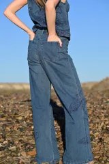 Pantalón de jean tiro alto con corte recto y holgado, confeccionado en denim azul con estampado de motivos naturales en tono azul oscuro.