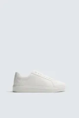Zapatilla urbana monocolor de diseño minimalista con cordones al tono, puntera redondeada y suela con volumen.
