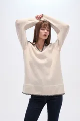 Sweater negro holgado con cuello en V y ribete en color crema en cuello, puños y ruedo.