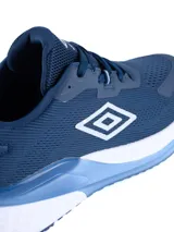 Championes deportivos Umbro modelo Daysprint, color azul marino con detalles en celeste y blanco. Presentan una capellada de malla transpirable, logo lateral de la marca y una suela con amortiguación en tonos blanco y celeste.