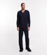 Pijama masculino de dos piezas compuesto por una camisa de manga larga con cierre frontal de botones y detalle de costuras en contraste, y un pantalón largo con cintura elástica. Confeccionado en tejido de media malla suave y transpirable.