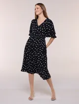 Vestido midi de calce holgado y caída fluida con escote en V cruzado, cintura elastizada fruncida y mangas cortas con volados superpuestos. Cuenta con un diseño estampado de flores grandes en tonos amarillo, blanco, azul marino y verde.