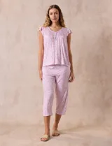 Conjunto de pijama marca René Rofé, compuesto por una remera de escote en V con botones y un pantalón capri con cintura elastizada, ambos en tejido soft estampado con motivos florales en tonos celeste y blanco.