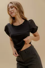 Remera negra de corte recto con cuerpo en jersey de algodón y mangas globo cortas en popelina con puños elásticos.