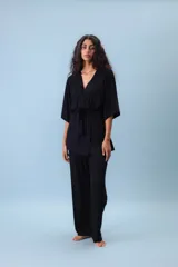 Conjunto de dos piezas (camisa y pantalón) de tejido acanalado gris, con camisa estilo kimono de manga ancha y cuello V cruzado, ajustada a la cintura con un lazo de tela.