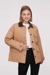 Campera color beige con cuello marrón de cuero sintético, cierre con botones a presión, cuatro bolsillos frontales y puños con botón.