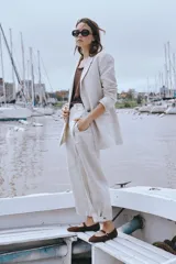 Pantalón de lino color beige, de corte recto y holgado, con bolsillos laterales y trabillas en la cintura.