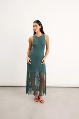 Vestido midi de crochet bordó con destellos de lurex, de cuello redondo y sin mangas, con falda terminada en largos flecos trenzados a mano.