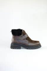 Bota corta de cuero marrón con puntera de gamuza, cuello de piel sintética negra, cierre con velcro y suela track negra.