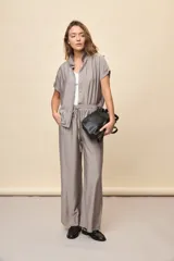 Pantalón gris de corte amplio y silueta fluida, con cintura elástica y cordón ajustable.
