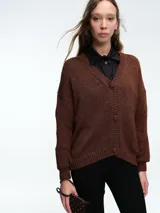 Cardigan de punto con hilo brillante, cuello en V y cierre frontal con botones. Presenta mangas largas con puños acanalados y un diseño de calce holgado.