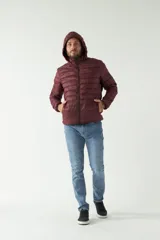 Campera de nylon color bordó con cuello, capucha removible y bolsillos laterales con cierre.