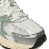 Championes New Balance modelo 530, con diseño retro de running. Presentan una base de malla blanca con superposiciones de cuero sintético en color blanco, detalles en verde menta y acentos plateados. Cuentan con entresuela amortiguada y suela de goma negra.