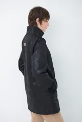 Chaquetón de efecto cuero en color marrón, con interior y detalles en corderito color bordó. Presenta cierre frontal con cremallera y botones a presión, cuello solapa y mangas largas con puños de corderito.