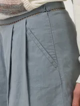 Short celeste de lino orgánico y viscosa, de tiro medio con pinzas delanteras y detalles de bandas con perforaciones geométricas en la cintura y los dobladillos.