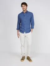 Camisa lisa azul, corte regular fit, cuello con botones y manga larga, confeccionada en algodón con acabado vintage.