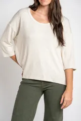 Remera color arena con efecto melange, de corte oversize, cuello redondo y mangas 3/4.