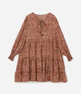 Vestido corto amplio color ladrillo con lunares irregulares color crema, cuello redondo con lazo, mangas largas con puños anchos y bajo fruncido.