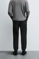 Pantalón tipo jogger de corte slim fit, confeccionado en tejido de algodón con elasticidad. Presenta cintura elástica ajustable con cordón, bolsillos frontales, bolsillos traseros de vivo y bajos con puños elásticos.