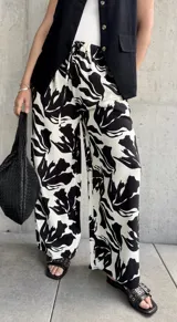 Pantalón palazzo de tiro alto con estampado floral abstracto en blanco y negro, con cintura elastizada y cordón ajustable.