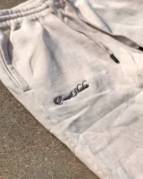 Pantalón de jogging color crema, corte holgado, con cintura elástica ajustable con cordón, puños elásticos y logo bordado en tono a tono.