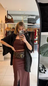 Falda midi color marrón, de tiro alto y confeccionada en lycra elastizada, con tajo frontal pronunciado.