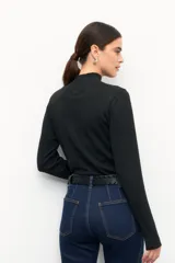Polera de tejido de punto con cuello alto y diseño de rayas verticales sutiles. Presenta un ajuste al cuerpo y mangas largas.