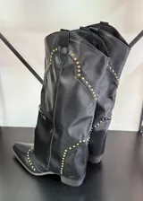 Botas texanas negras de caña alta con detalles de tachas doradas.