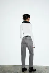 Jeans de tiro alto con corte mom fit, cinco bolsillos y cierre frontal con cremallera y botón metálico.