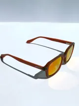 Lentes de sol con montura color marrón y lentes espejados color naranja. Protección UV 400 y tecnología polarizada. Marca Osten, modelo Lima 2610.