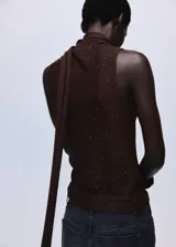 Top sin mangas de tejido de punto con brillos, diseño entallado y cuello alto con detalle de fular largo integrado.