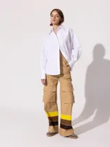 Pantalón cargo wide color beige confeccionado en denim 100% algodón. Posee recortes y bolsillos grandes con tapa en ambas piernas.