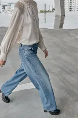 Jeans de tiro alto, color celeste claro con efecto desgastado y lavado. Modelo de corte holgado (loose baggy) con cierre frontal de botones metálicos y cinco bolsillos.