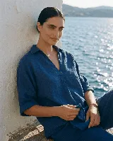 Blusa de lino azul con cuello camisero y escote en V, de manga corta holgada.