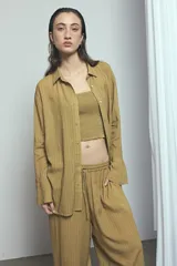Camisa de viscosa con estampado de rayas verticales en tonos rosado y marrón, de corte oversize, con cuello camisero, cierre frontal de botones y mangas largas acampanadas.