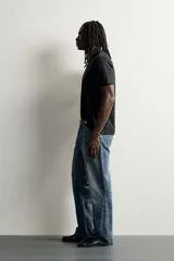Jeans flare fit de denim negro, tiro medio, ajustados arriba y con botamanga acampanada. Cuentan con cinco bolsillos, lavado efecto gastado y bajo con acabado irregular. Cierre frontal con cremallera y botón.