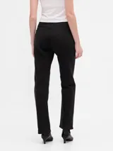 Pantalón de jean de tiro alto, corte recto, color negro gastado, con cinco bolsillos y presillas para cinturón.