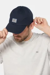 Gorro con visera de lona azul marino, con parche rectangular bordado en el frente.