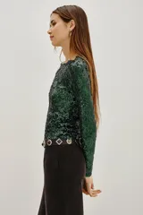 Remera de manga corta con diseño de lentejuelas negras formando un patrón de rombos. Presenta cuello redondo y un ajuste entallado.