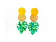Pendientes largos con diseño tropical, compuestos por una flor amarilla en la parte superior, un disco dorado texturizado en el centro y una hoja de monstera verde marmoleada en la base.