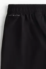 Pantalón deportivo negro de corte estándar y piernas rectas, confeccionado en tejido funcional ripstop con tecnología DryMove™. Cuenta con cintura elástica con cordón de ajuste oculto, bolsillos laterales con cierre y detalles perforados en las piernas.