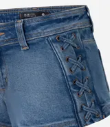 Short de jean azul con cierre frontal, trabillas en la cintura y detalle de cordones entrelazados en los laterales. Presenta un corte ajustado y acabado clásico.