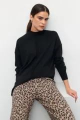 Polera color beige de manga larga con puños elastizados y aberturas laterales.