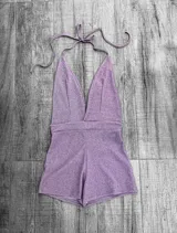 Mono corto de color rojo, con escote halter y espalda descubierta.